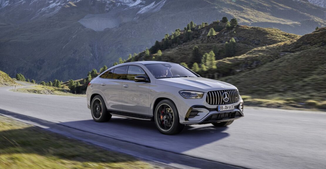 a car driving on a road with mountains in the background